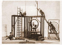 Celkový pohled na Heythumovu scénickou konstrukci k Frejkově inscenaci Když ženy něco slaví. Vlevo dole V. Nezval a  K. Teige. (Divadlo mladých, 1926)