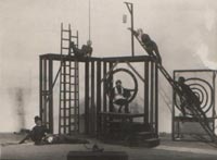 Celkový pohled na  Heythumovu scénickou konstrukci k Frejkově inscenaci Když ženy něco slaví. Vlevo dole V. Nezval a  K. Teige. (Divadlo mladých, 1926)
